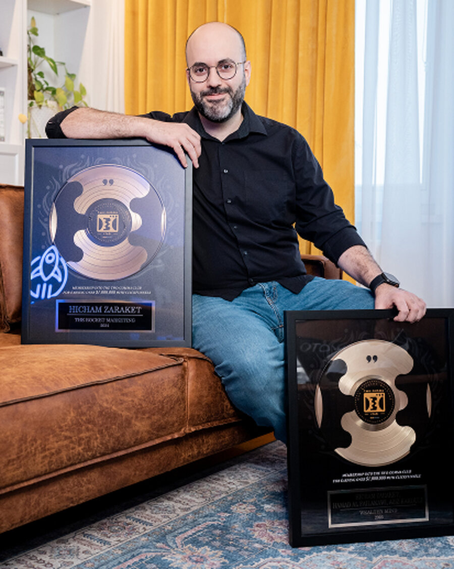 Hicham Zaraket, founder of The Rocket Marketing, holding the two ClickFunnels Two Comma Club awards — The Rocket Marketing and Wealthy Mind